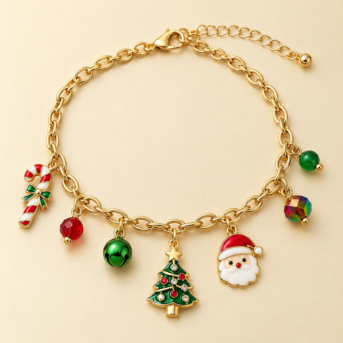 Gold Christmas charm bracelet with Santa, tree, candy cane and red-green beads on a pale cream studio backdrop.