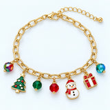 Gold Christmas charm bracelet with snowman, tree, gift and colored beads on a light blue-white studio backdrop.