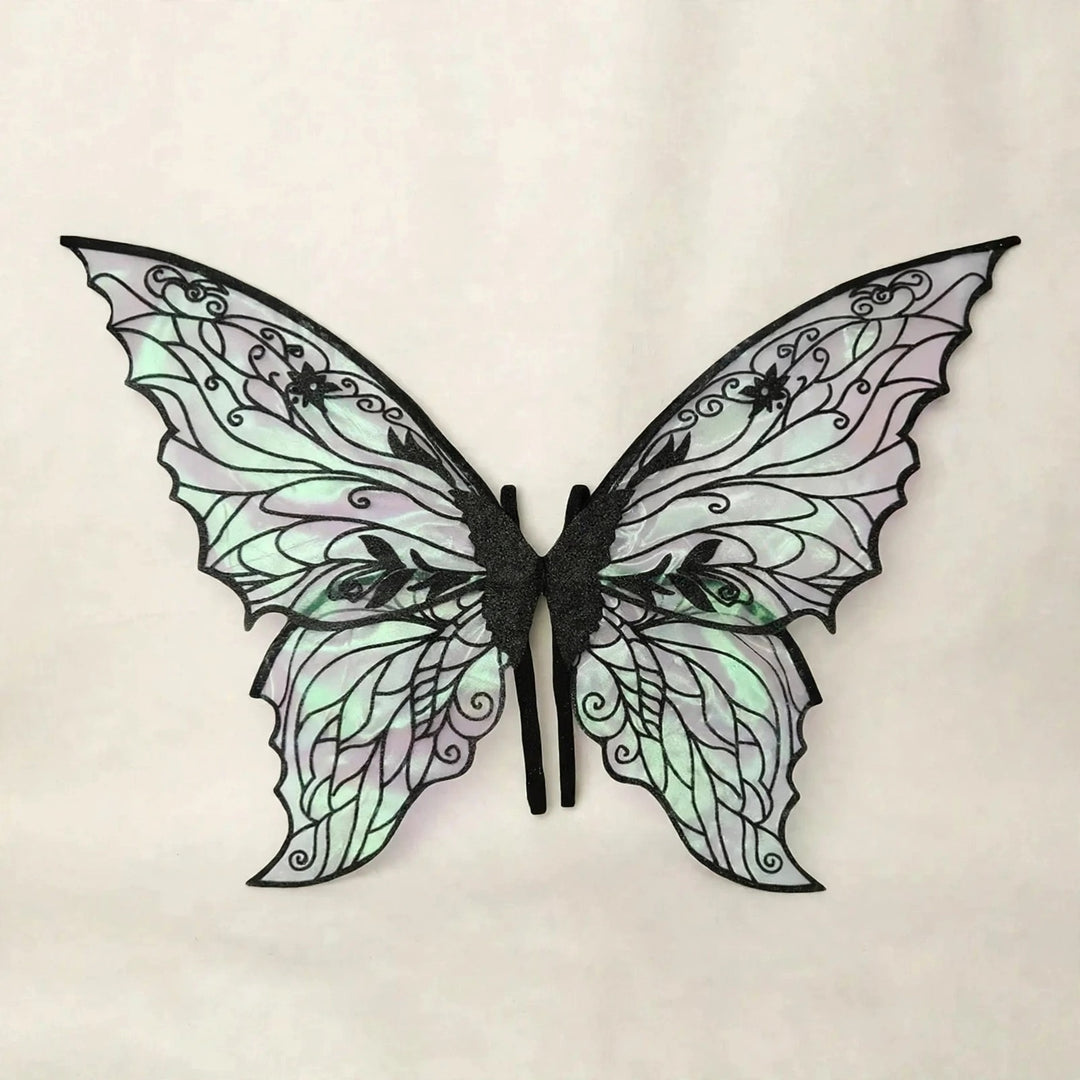Fairy wings with black floral patterns, iridescent panels, and scalloped edges spread against a cream background.