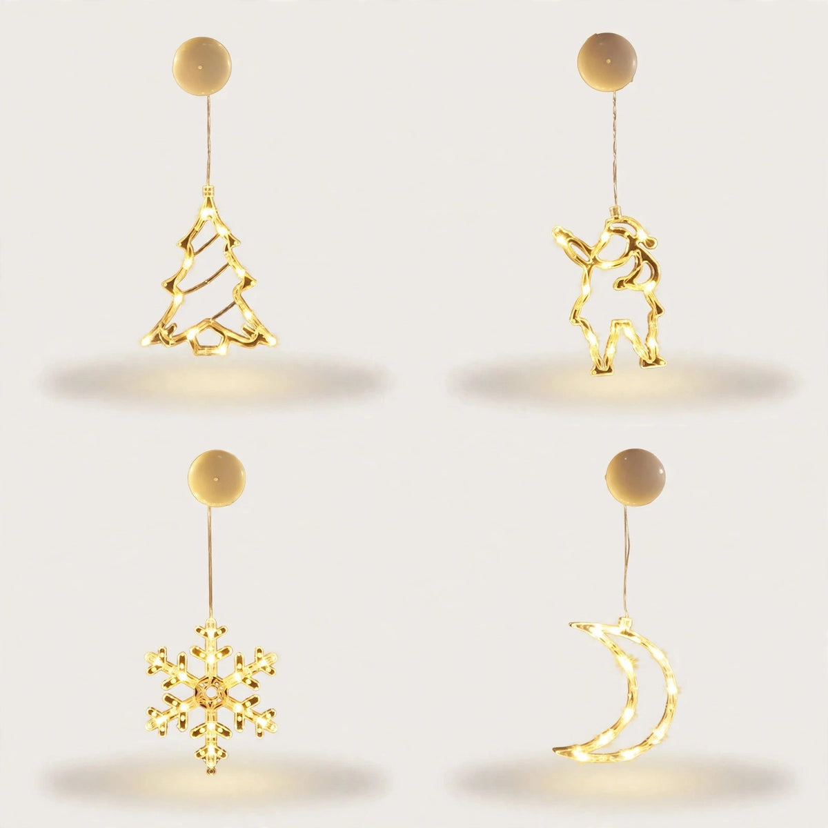 Four illuminated clear ornaments shaped as a Christmas tree, Santa, snowflake, and crescent moon hang beneath round cream housings against white.
