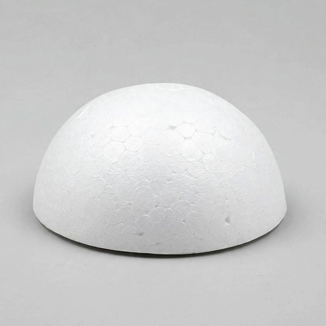 A white foam half ball with visible surface indentations sits on its flat base against a gray background.