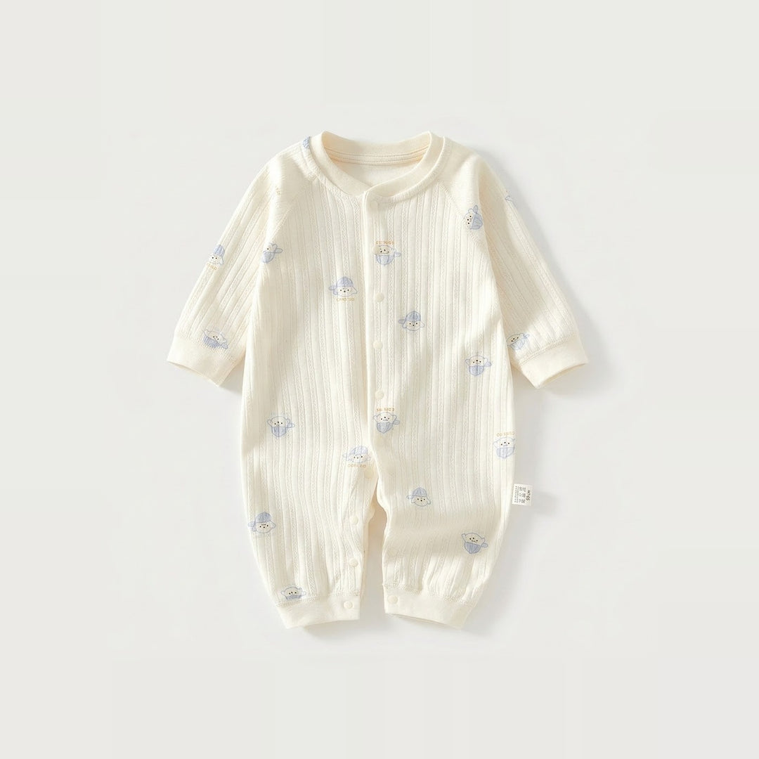 Cream long-sleeve baby romper with vertical fabric texture and small blue-hat dog motifs lies flat against a light background.