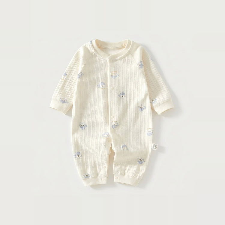 Cream long-sleeve baby romper with vertical fabric texture and small blue-hat dog motifs lies flat against a light background.