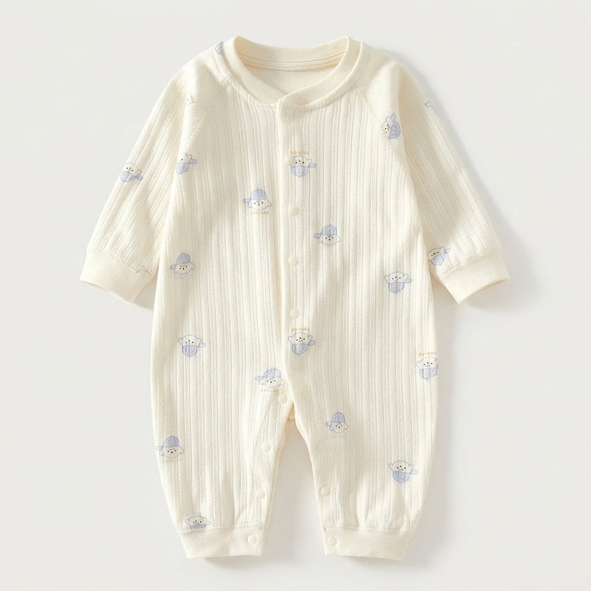 Cream textured long-sleeved baby romper with blue dog prints and front snap fasteners lies flat against a pale background.