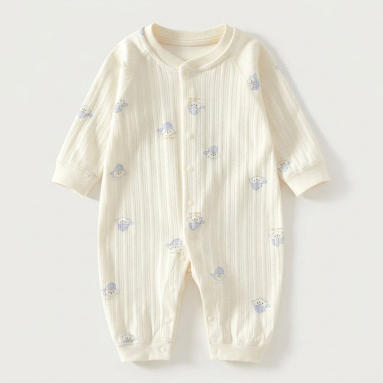 Cream textured long-sleeved baby romper with blue dog prints and front snap fasteners lies flat against a pale background.