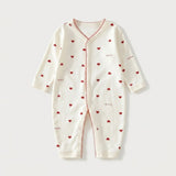An off-white long-sleeve baby romper with a front zipper, decorated with small red hearts and the word 'Love' printed in red on the front, set against a light gray background.