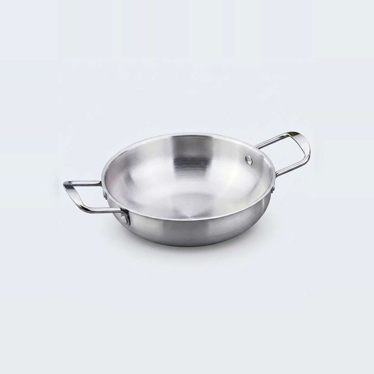 A silver stainless steel paella pan with two rectangular loop handles sits on a light gray background.