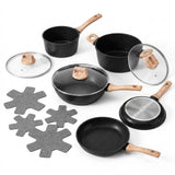 A 7-piece non-stick cookware set in black with light wood handles and lids, including a saucepan, two pots, a frying pan, a glass lid, and four gray star-shaped coasters, arranged on a white background.