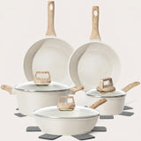 A 5-piece non-stick cookware set in a speckled cream finish with light natural wood handles and glass lids, arranged on gray coasters against a solid off-white background.