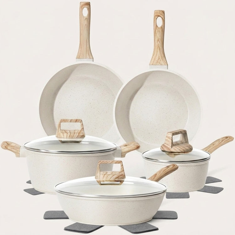 A 5-piece non-stick cookware set in a speckled cream finish with light natural wood handles and glass lids, arranged on gray coasters against a solid off-white background.