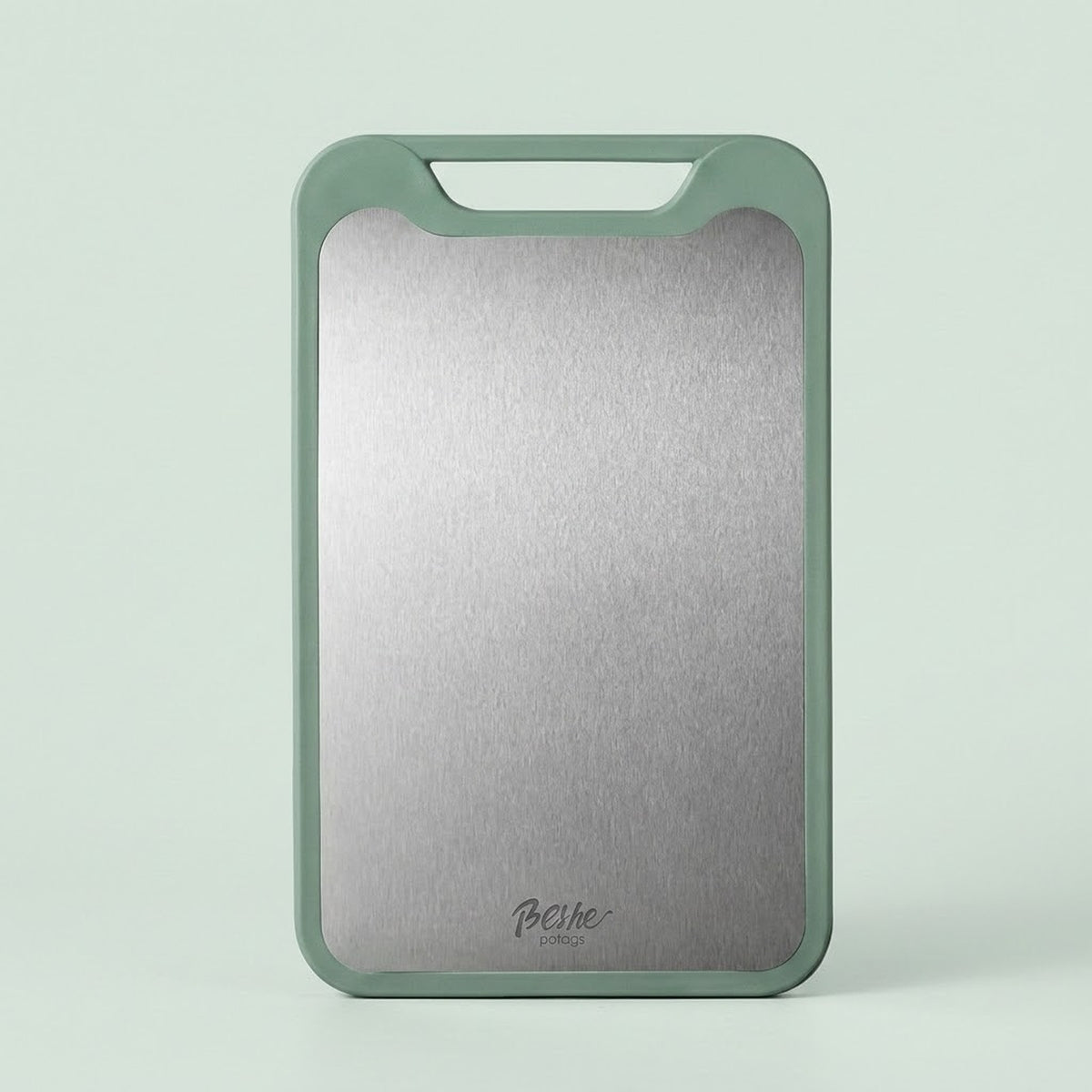 A rectangular cutting board with a brushed silver metal center and a sage green border, standing upright against a light mint green background. The brand name 'Bocle' is printed near the bottom.