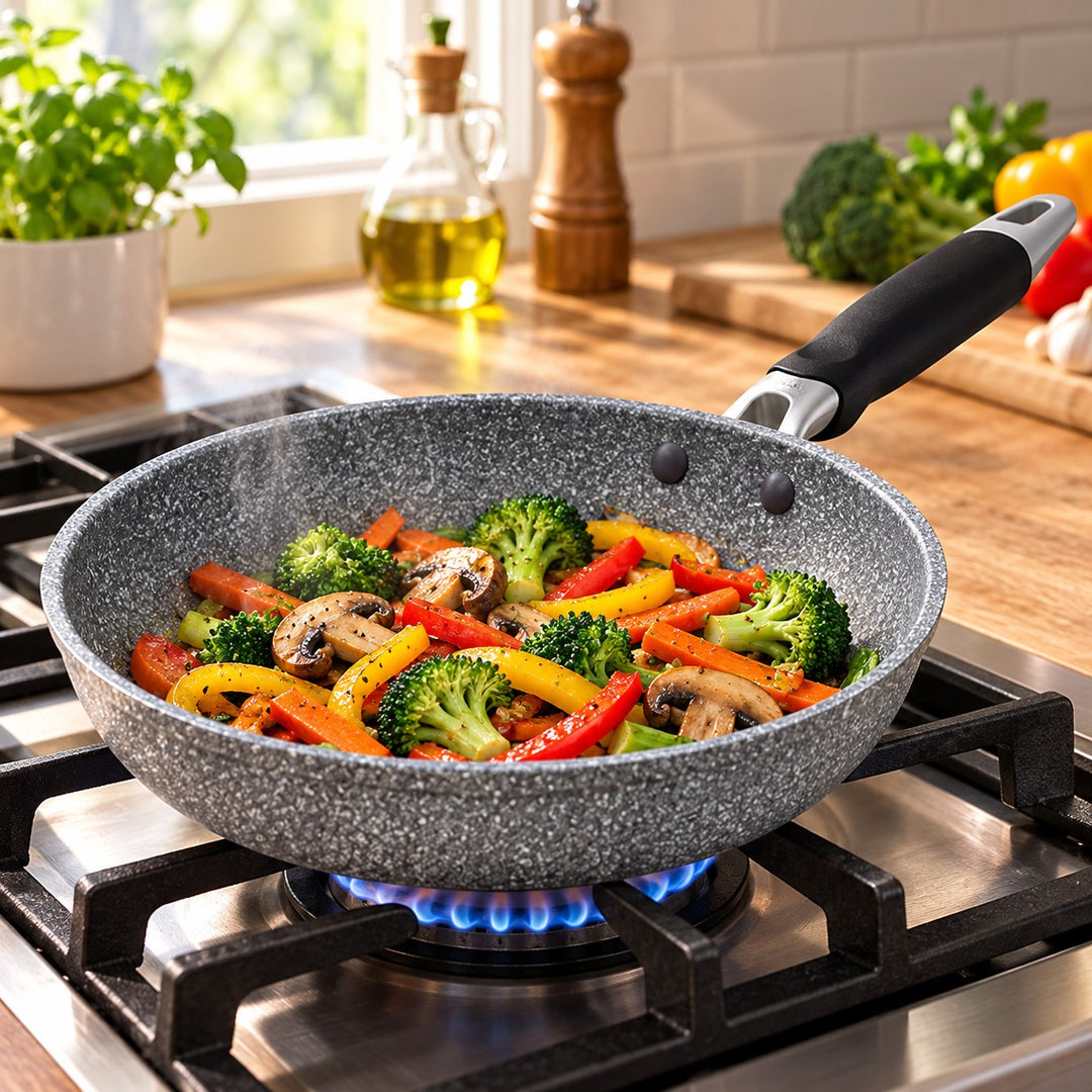 Grey speckled non-stick frying pan cooks vegetables over a gas flame in a home kitchen.