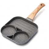 Gray speckled egg frying pan with two round wells, a ridged grill section, and a wood-grain handle against a white background.
