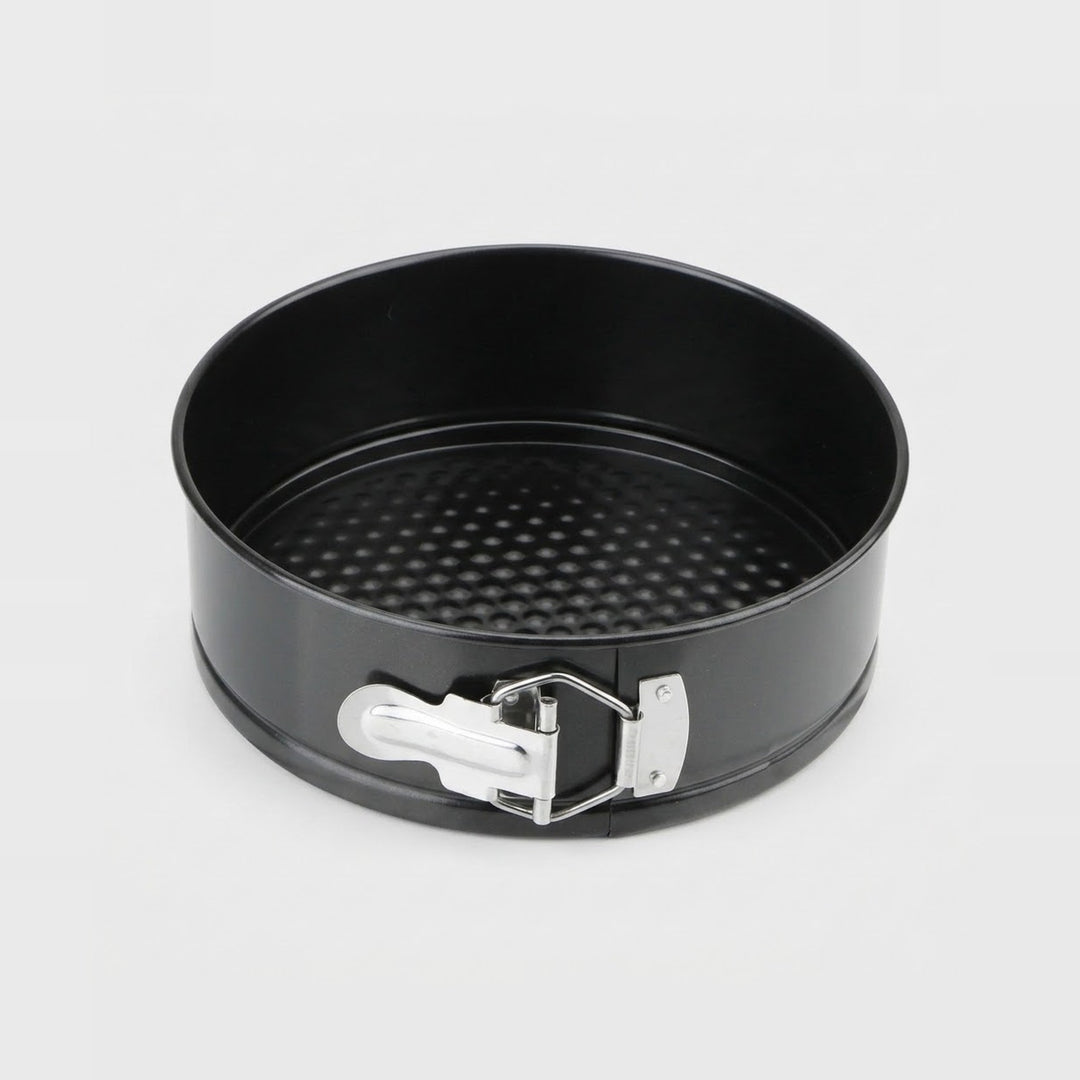 A black springform pan with a silver metal release clasp, shown from a top-down angle on a light gray background.