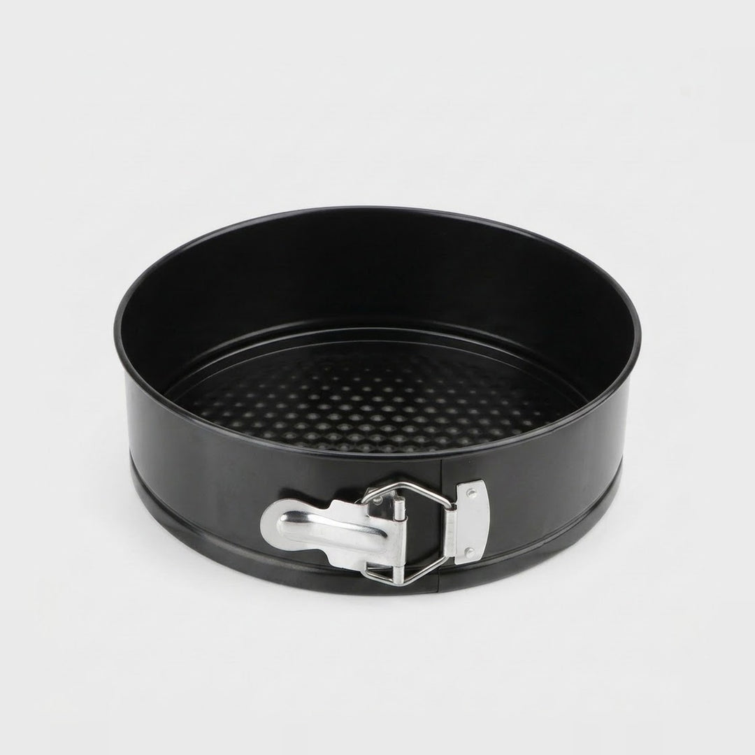 A black springform cake pan with a silver metal clasp, shown from a top-down angle on a light gray background.