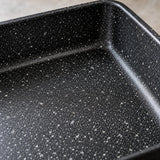 Japanese omelet pan close-up shows its smooth black speckled nonstick coating and raised rim.