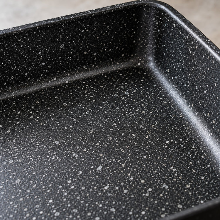 Japanese omelet pan close-up shows its smooth black speckled nonstick coating and raised rim.