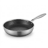 Stainless steel frying pan with a dark honeycomb interior and silver handle on a white background.