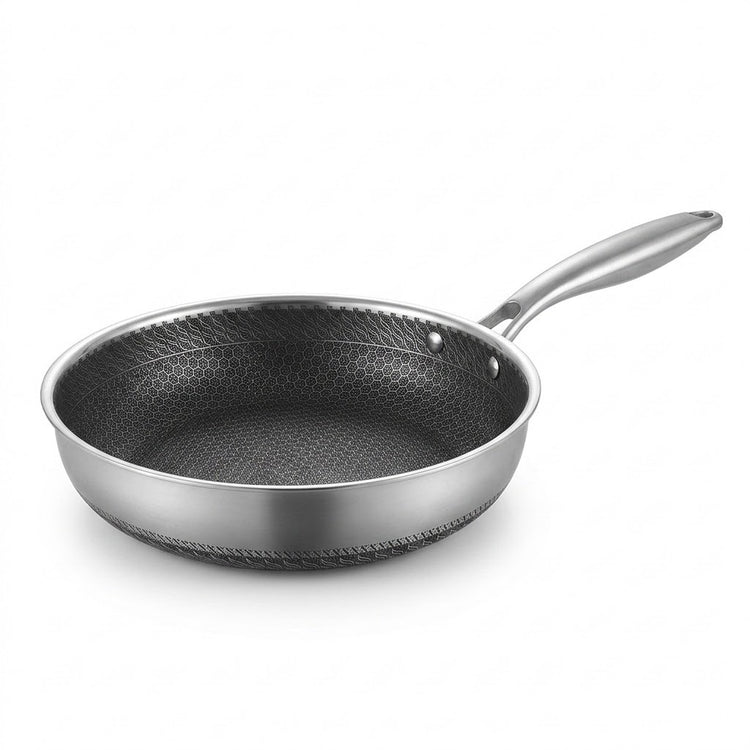 Stainless steel frying pan with a dark honeycomb interior and silver handle on a white background.