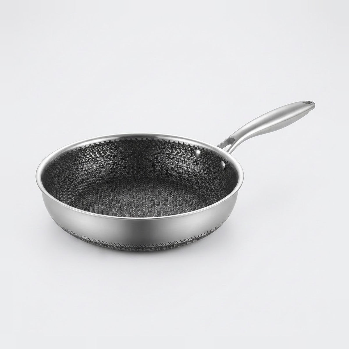 Stainless steel frying pan with a dark textured interior, two visible handle rivets, and a silver handle on a light background.