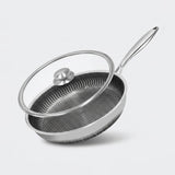 A stainless steel frying pan with a textured non-stick interior and a clear glass lid with a silver metal rim and knob, shown on a light gray background.