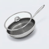 A stainless steel frying pan with a textured non-stick interior and a clear glass lid with a silver knob, shown on a light gray background.