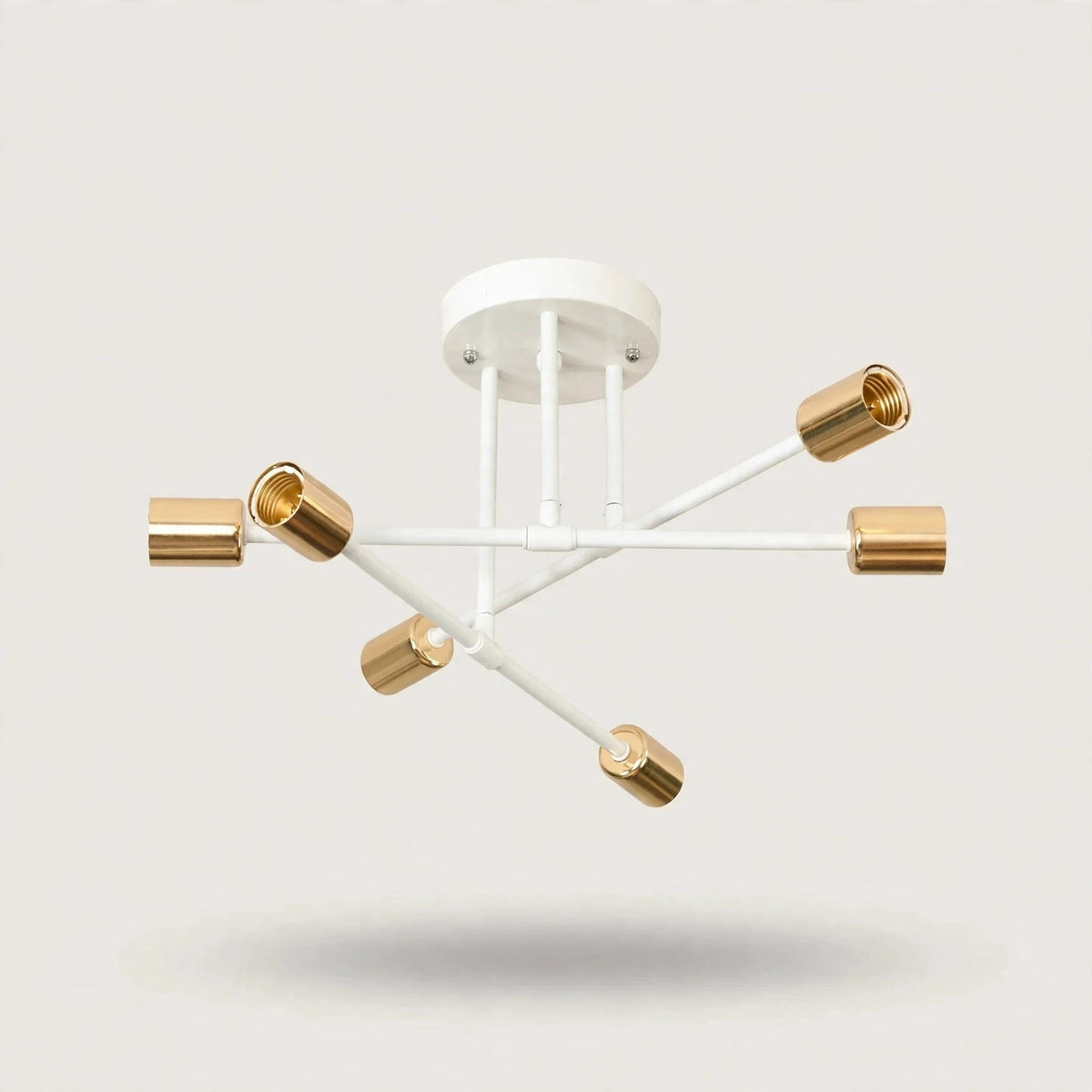 White and gold iron sputnik chandelier with six gold cylindrical sockets on crossing white arms against a plain background.