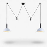 A modern two-light pendant chandelier with black metal hardware and white dome-shaped shades, suspended against a clean white background.