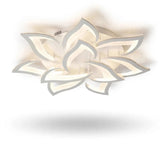 A modern semi-flush mount ceiling light fixture with a sculptural, multi-layered lotus-like design, shown illuminated against a white background.