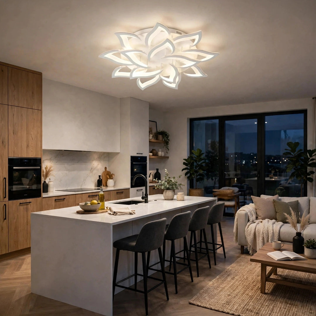 A modern flower-shaped LED ceiling light glowing with a warm white light, installed in a contemporary kitchen and living room setting.