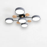 Modern multi-light ceiling fixture with six circular white shades, dark gray cylindrical rims, and natural wood accents on a black metal frame, shown against a plain white wall.