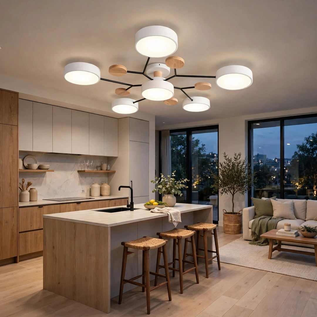 A modern multi-light ceiling fixture with white cylindrical shades and natural wood accents, installed in a contemporary kitchen and living space.