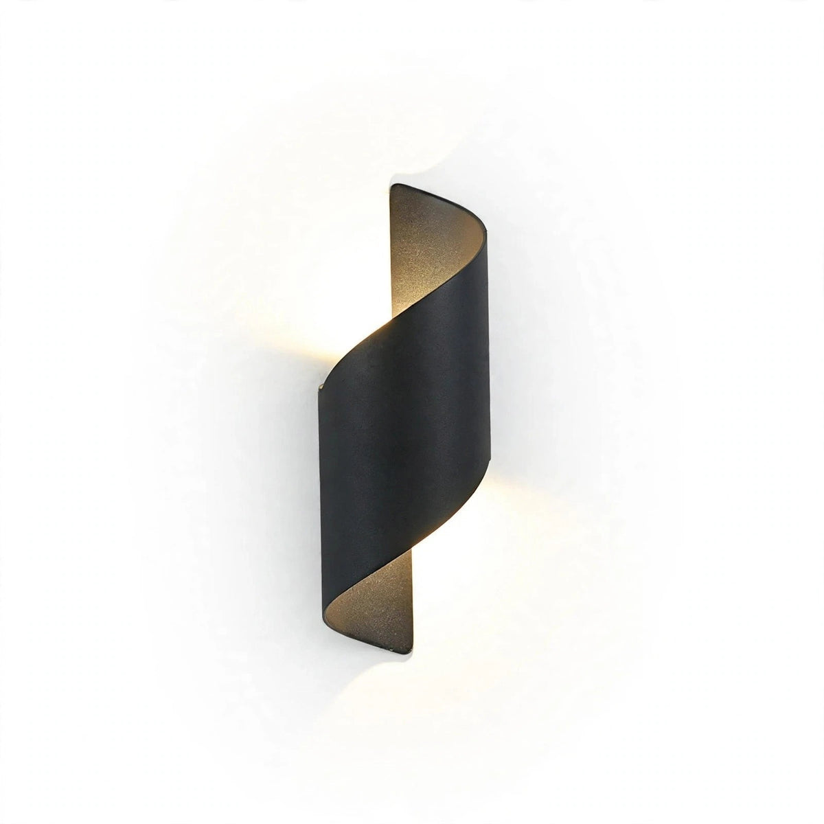 A modern spiral-shaped wall sconce in a matte black finish, emitting a warm glow against a clean white background.
