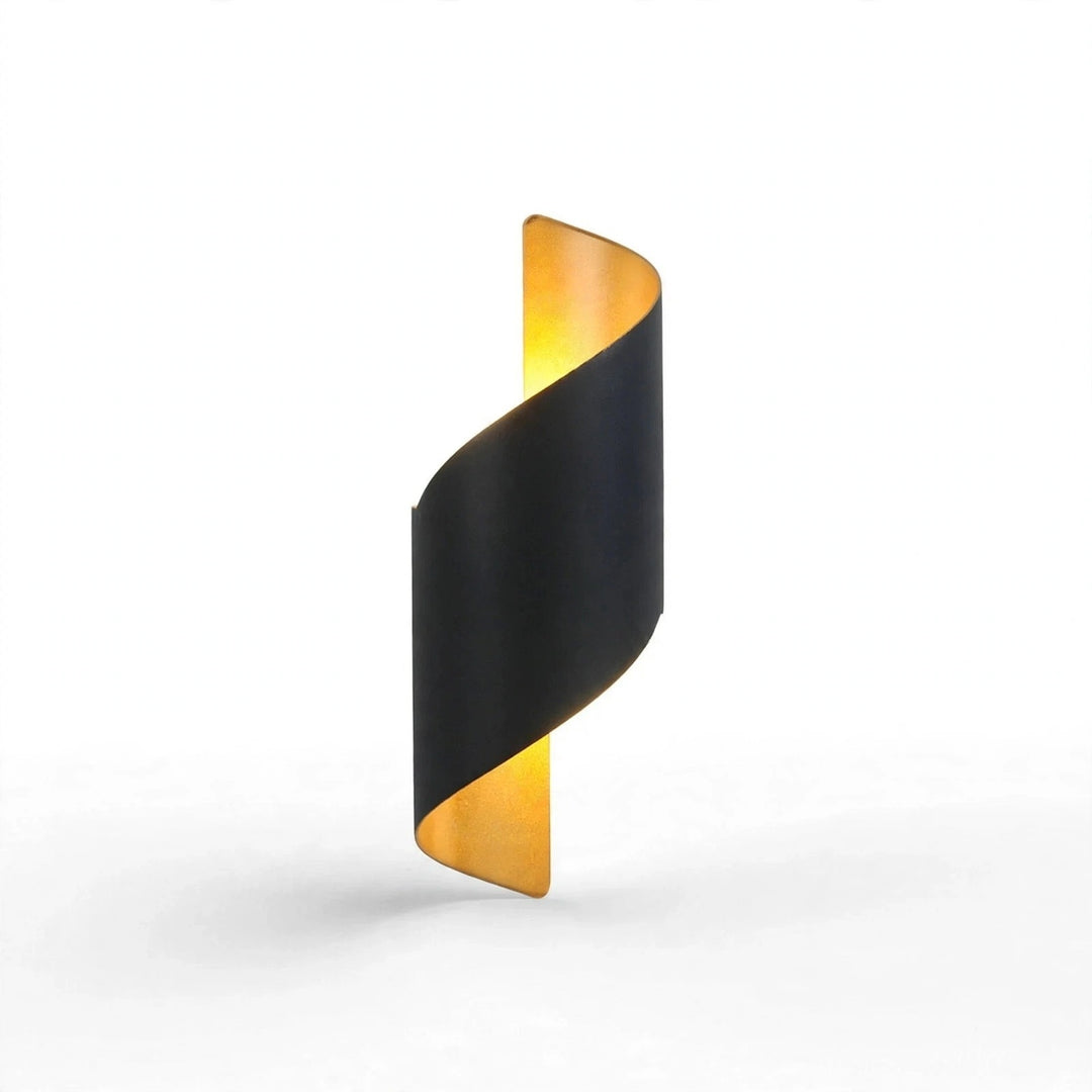 A modern spiral-shaped wall sconce with a matte black outer wrap and a warm gold inner panel, casting a soft yellow light upward against a clean white background.