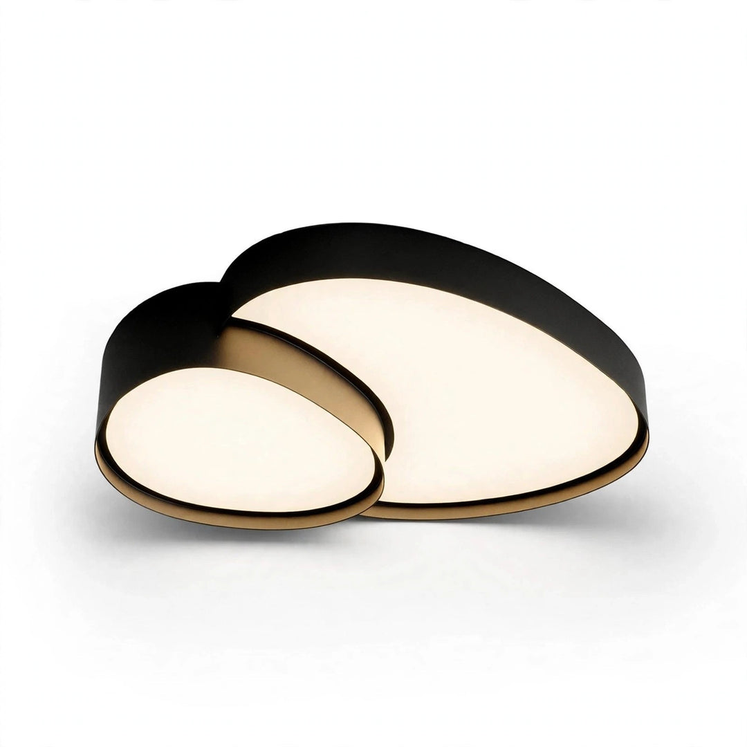 Black ceiling light with gold-toned trim and two overlapping rounded acrylic panels glowing warmly against a white background.