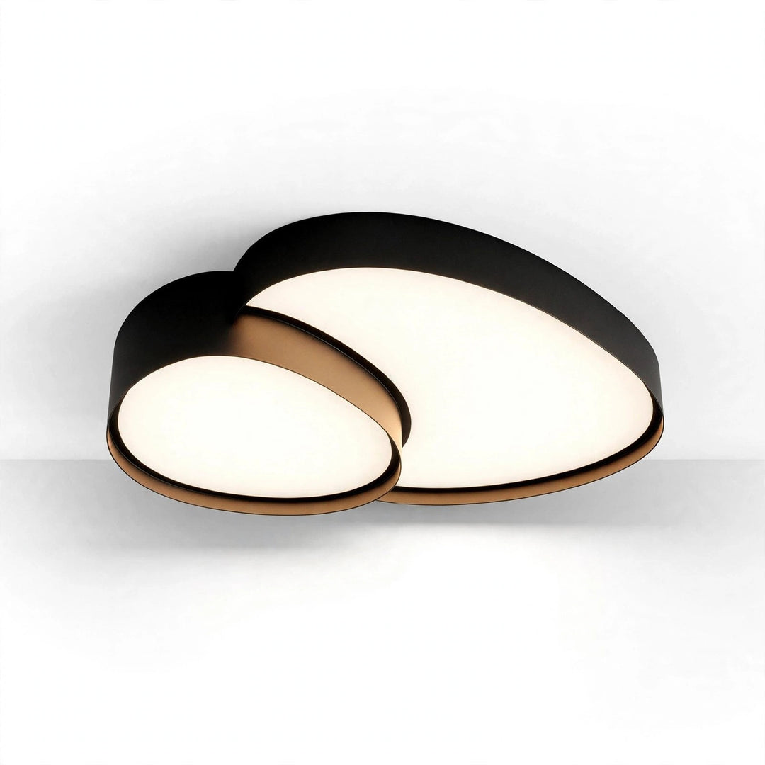 Black ceiling light with bronze-toned trim and overlapping illuminated acrylic panels shown at an angle against a white and pale gray background.