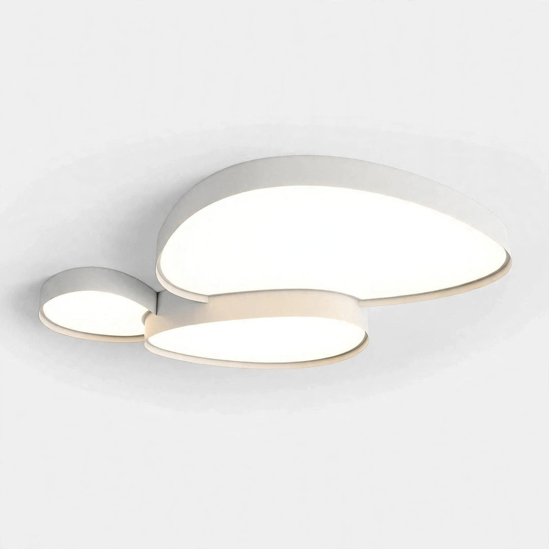 A modern three-light ceiling fixture with organic, flowing shapes in a warm white finish, shown illuminated against a clean white ceiling.