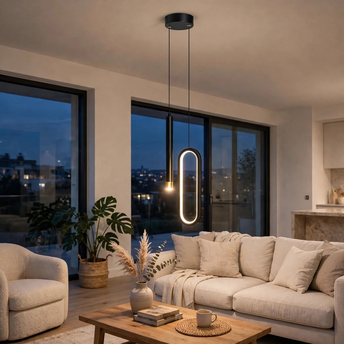 A modern black pendant light with an oval-shaped illuminated LED ring hangs over a beige sofa in a contemporary living room with large windows and a wooden coffee table.