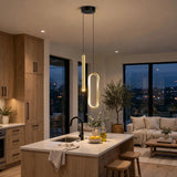 Modern pendant lights hanging over a kitchen island in a contemporary apartment, with warm glowing cylindrical and oval LED fixtures in a well-lit interior.
