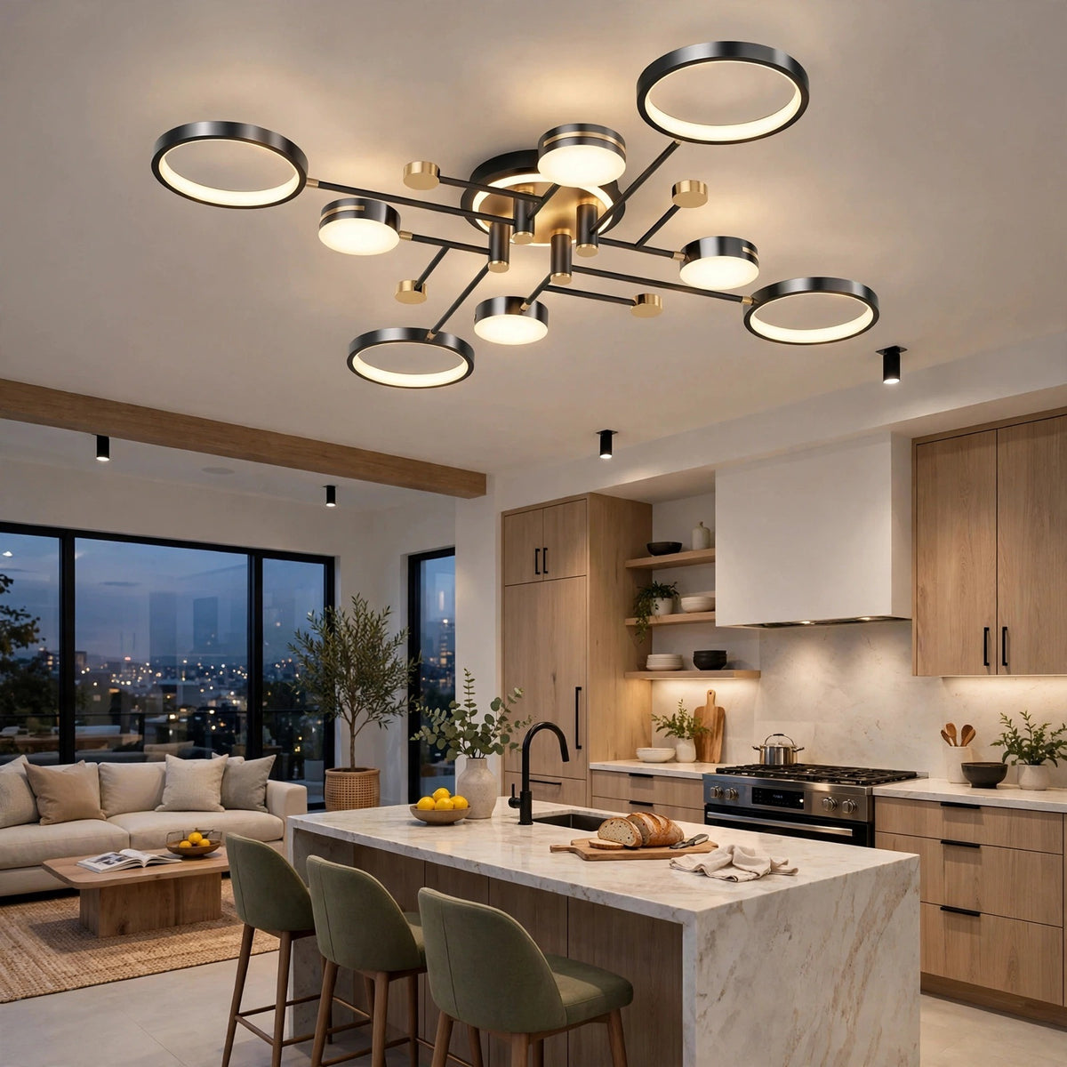 A black ceiling light with circular rings and gold accents illuminates a kitchen with wooden cabinets, a white island, and green stools.