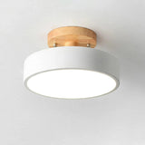 A modern semi-flush ceiling light fixture with a white cylindrical shade and a natural light wood ceiling mount, shown against a plain white ceiling.