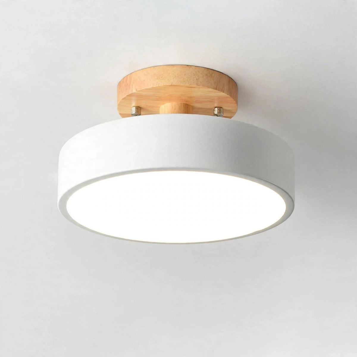 A modern semi-flush ceiling light fixture with a white cylindrical shade and a natural light wood ceiling mount, shown against a plain white ceiling.