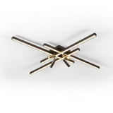 Black crossed linear-bar ceiling light with glowing bars and warm-lit cylindrical spotlights on a plain white background.