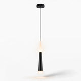 A modern black pendant light with a sleek tapered shade and a warm glowing bulb, suspended by a thin cord from a circular ceiling canopy against a plain white background.