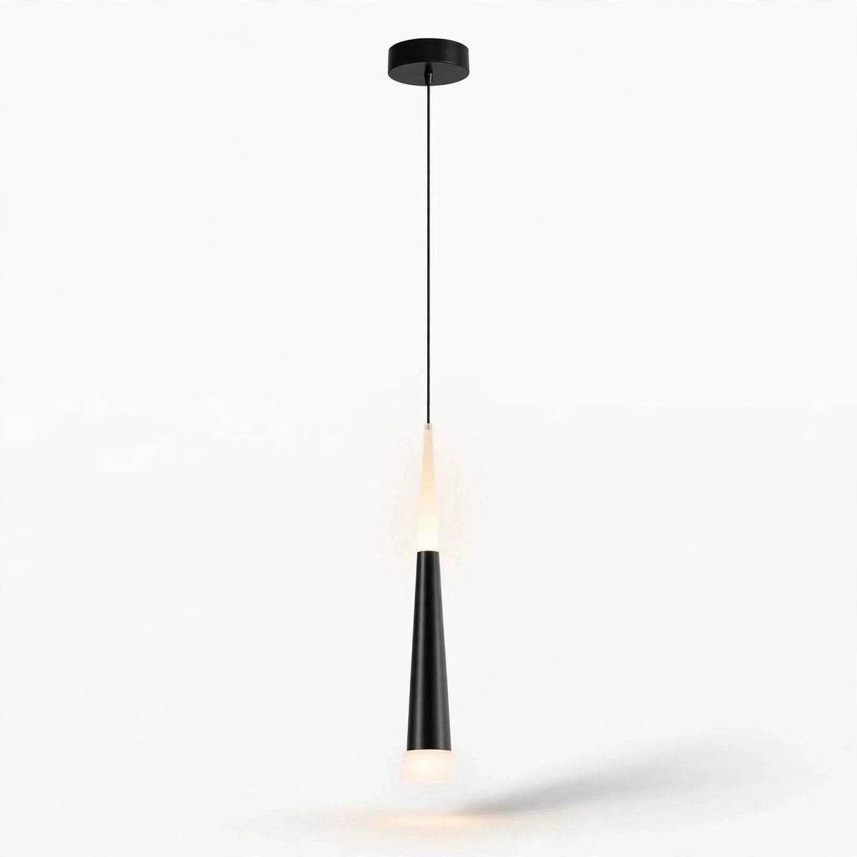 A modern black pendant light with a sleek tapered shade and a warm glowing bulb, suspended by a thin cord from a circular ceiling canopy against a plain white background.