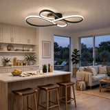 Modern ceiling light fixture with two interlocking circular rings in a black finish and white LED lighting, installed in a contemporary kitchen and living room setting.