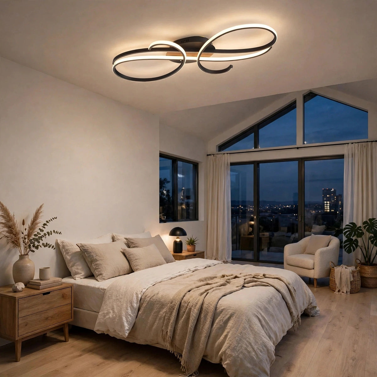 Modern ceiling light fixture with interlocking abstract oval rings in black and brushed silver, illuminated in a contemporary bedroom setting.