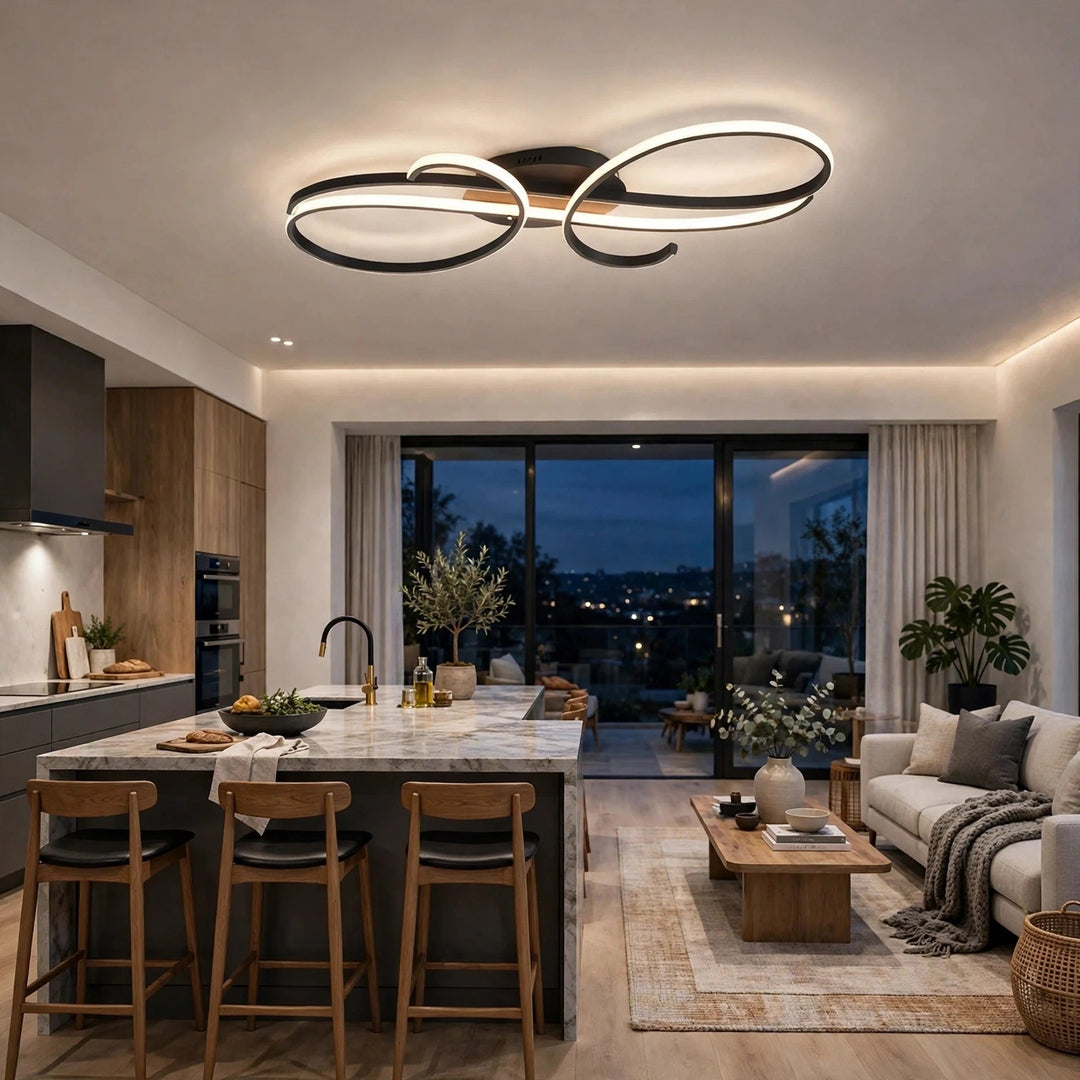 A black ceiling light with glowing curved loops illuminates an open kitchen and living area with a marble island and cream sofa.