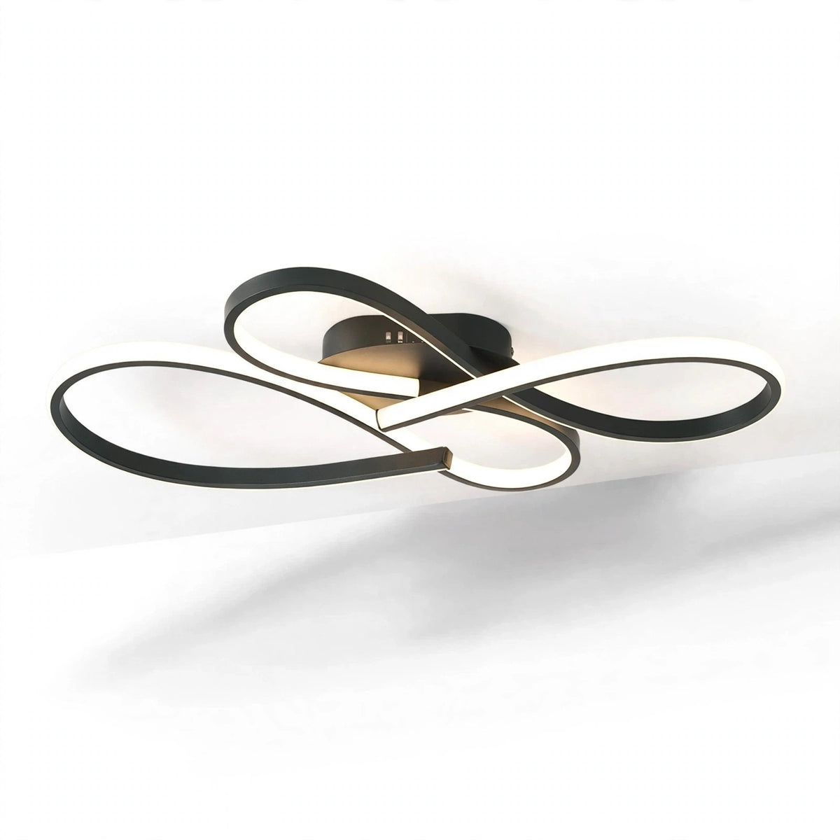 Modern ceiling light fixture with interlocking curved bands in black and white, mounted on a white ceiling with a soft shadow below.
