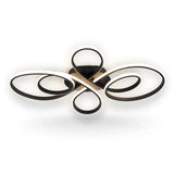 A black ceiling light with intersecting spiral loops and glowing white edges is shown against a plain white background.